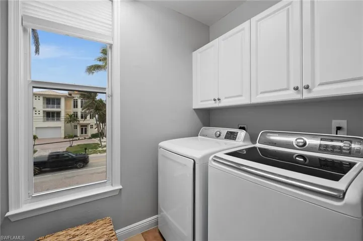 Clothes washing area featuring independent washer and dryer and cabinets