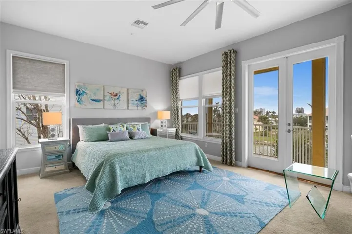 Bedroom with ceiling fan, light colored carpet, access to exterior, and multiple windows
