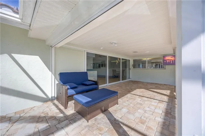 Swimming pool featuring a patio area, glass enclosure, and a sunroom