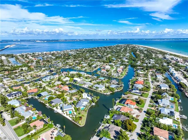Aerial view of property and surrounding area featuring a large body of water and nearby suburban area