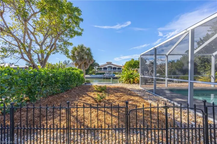 Fenced backyard with glass enclosure and a sunroom