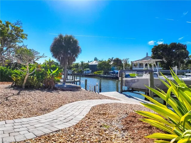 View of yard with a lanai, a sunroom, an outdoor pool, and a water view