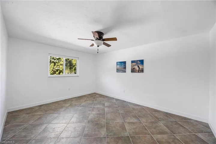 Unfurnished room featuring baseboards and ceiling fan