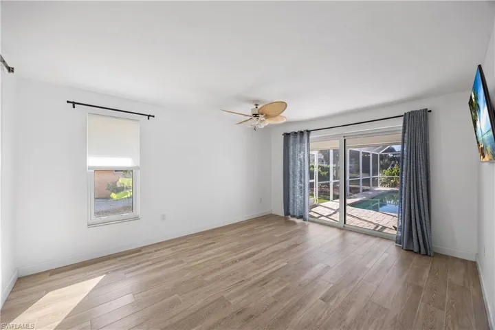 Dining space with light wood-style floors, a fireplace, and a ceiling fan