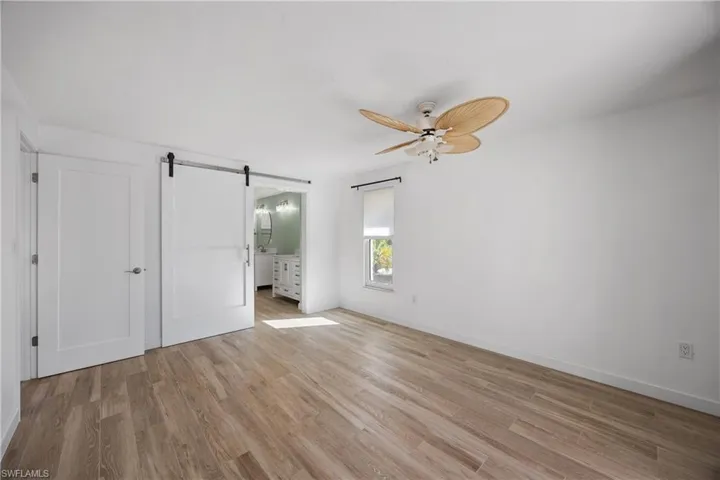 Empty room with light wood-type flooring, plenty of natural light, and a ceiling fan