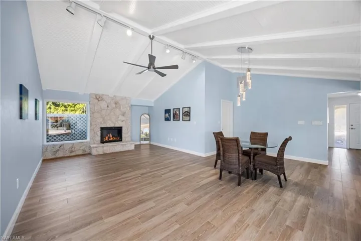 Unfurnished living room with light wood-type flooring, a fireplace, ceiling fan, and rail lighting