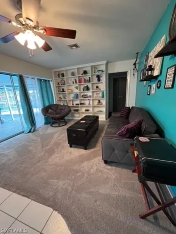 Living room featuring ceiling fan and carpet floors