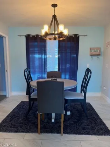 Tiled dining space featuring a notable chandelier
