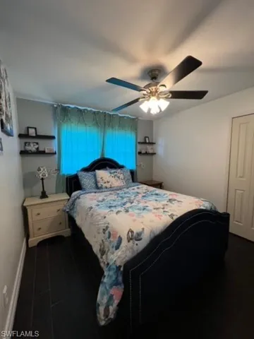 Bedroom with dark wood-type flooring and ceiling fan