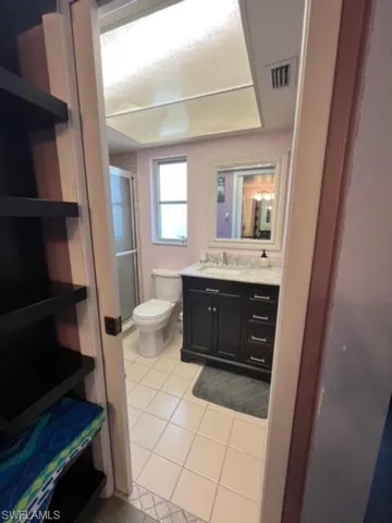 Bathroom with tile flooring, toilet, and vanity with extensive cabinet space