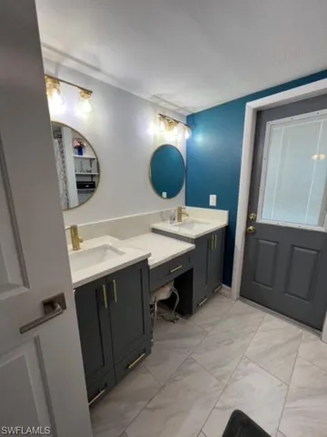 Bathroom featuring tile floors and double vanity