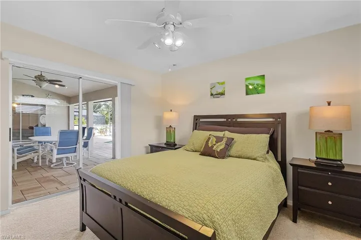 Bedroom with lofted ceiling, ceiling fan, and light carpet
