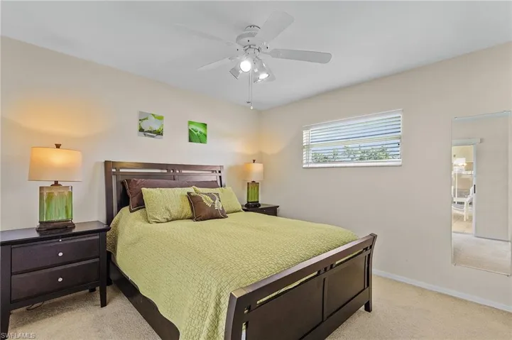 Bedroom with ceiling fan and light carpet