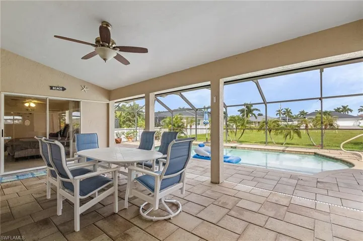 Sunroom / solarium featuring vaulted ceiling, ceiling fan, and a pool