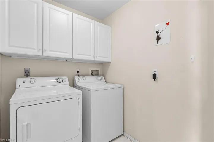 Washroom featuring cabinets and separate washer and dryer