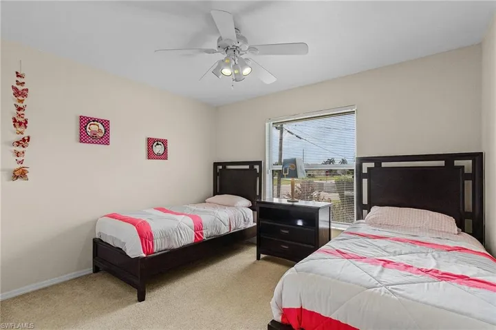 Carpeted bedroom featuring ceiling fan