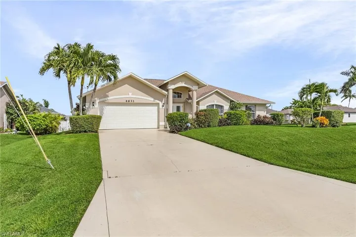 Ranch-style home featuring a garage and a front lawn