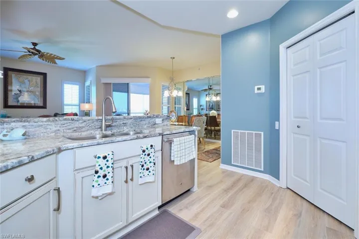 Kitchen with visible vents, white cabinetry, a sink, stainless steel dishwasher, and light wood-type flooring