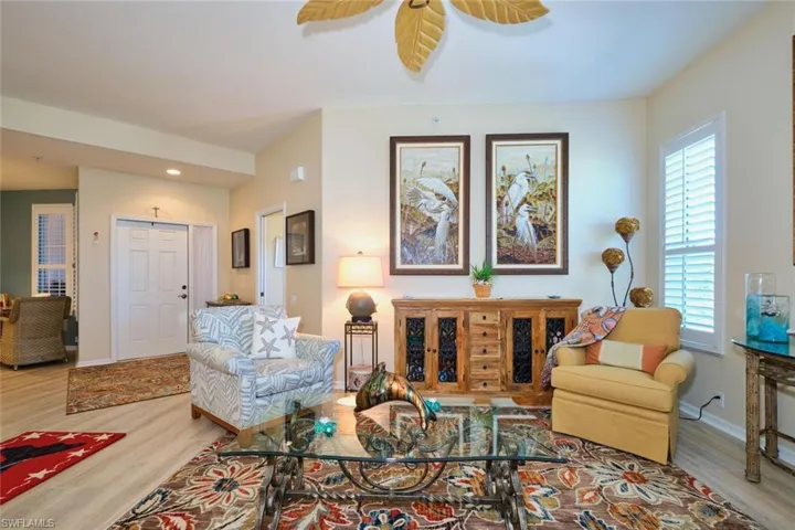 Living area with ceiling fan, baseboards, and wood finished floors
