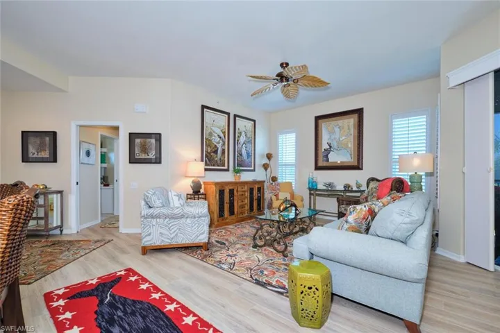 Living room featuring a wealth of natural light, wood finished floors, and a ceiling fan