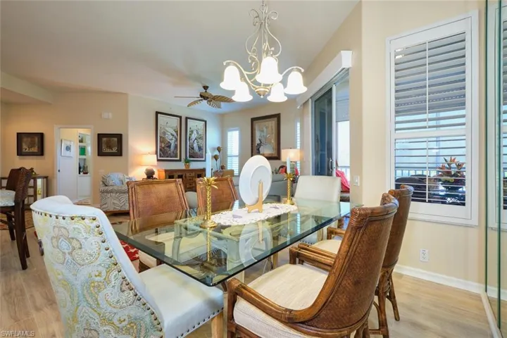 Dining room featuring ceiling fan with notable chandelier, light wood-style floors, and baseboards
