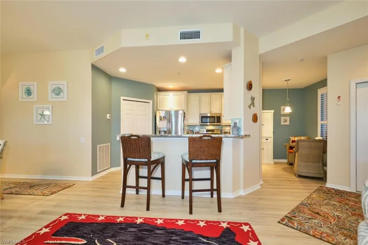 Kitchen with a kitchen breakfast bar, visible vents, and stainless steel appliances