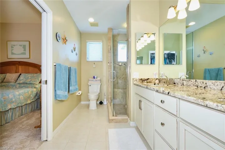 Ensuite bathroom featuring visible vents, toilet, vanity, tile patterned floors, and ensuite bath