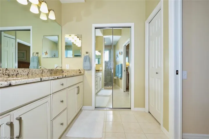 Full bath featuring baseboards, a shower stall, vanity, and tile patterned flooring