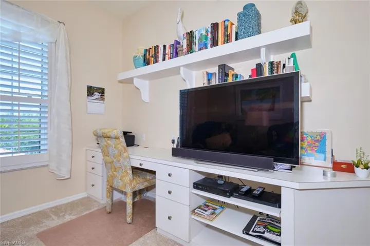 Home office with baseboards and light carpet