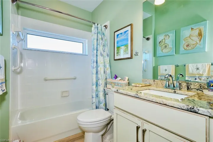 Full bath with vanity, shower / tub combo, and toilet