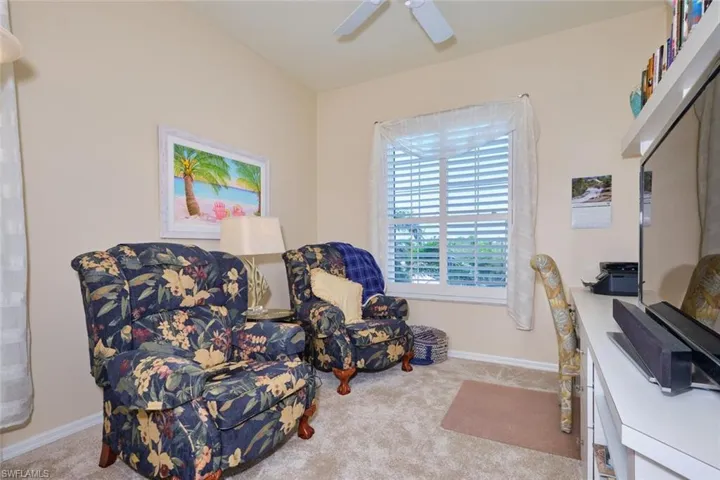 Living area featuring baseboards, carpet, and ceiling fan