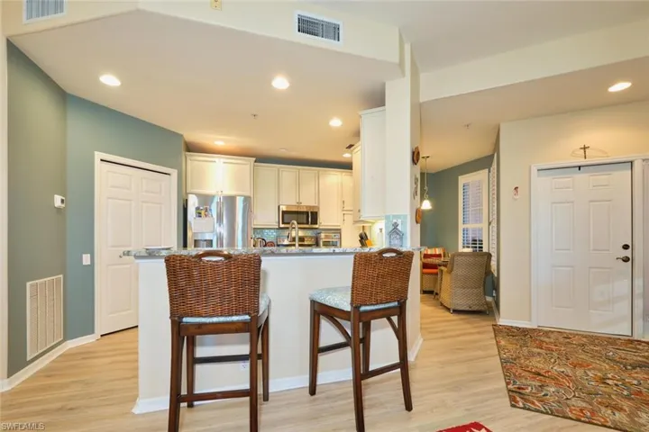 Kitchen with a breakfast bar, visible vents, and stainless steel appliances
