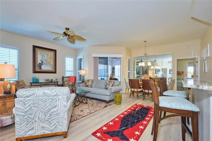 Living area featuring light wood finished floors and ceiling fan with notable chandelier