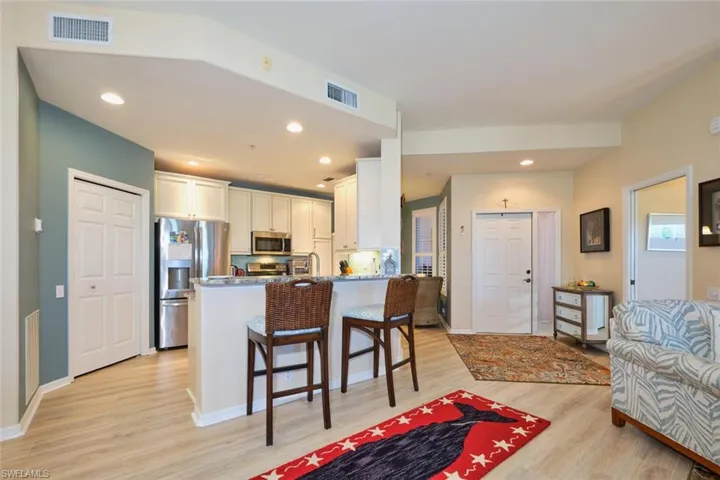 Kitchen featuring a kitchen bar, a peninsula, visible vents, and appliances with stainless steel finishes