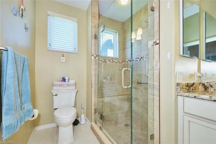 Bathroom with tile patterned floors, a shower stall, vanity, and baseboards