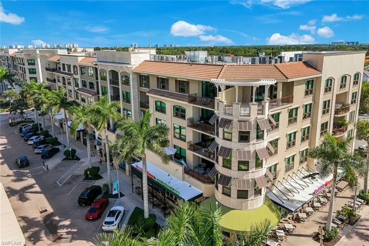 Multi-story building featuring a prominent round turret with awnings and balconies