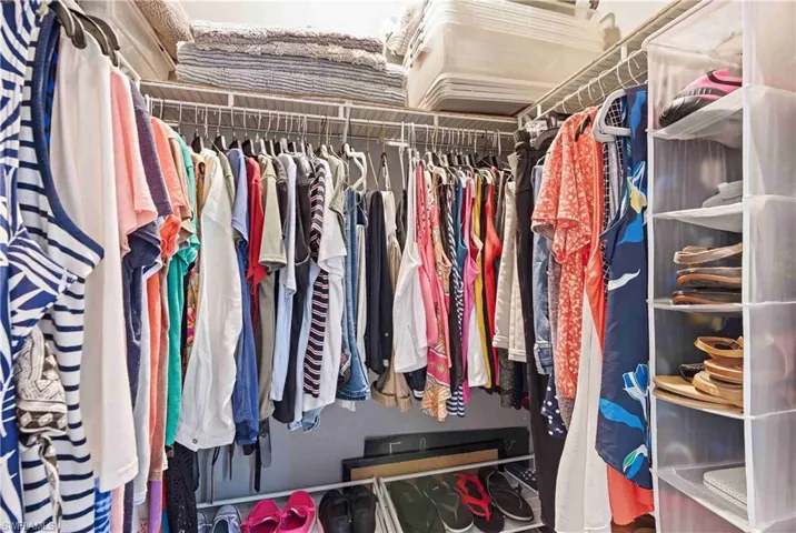 Walk-in closet featuring built-in wire shelving, ample hanging rods, and integrated overhead storage solutions