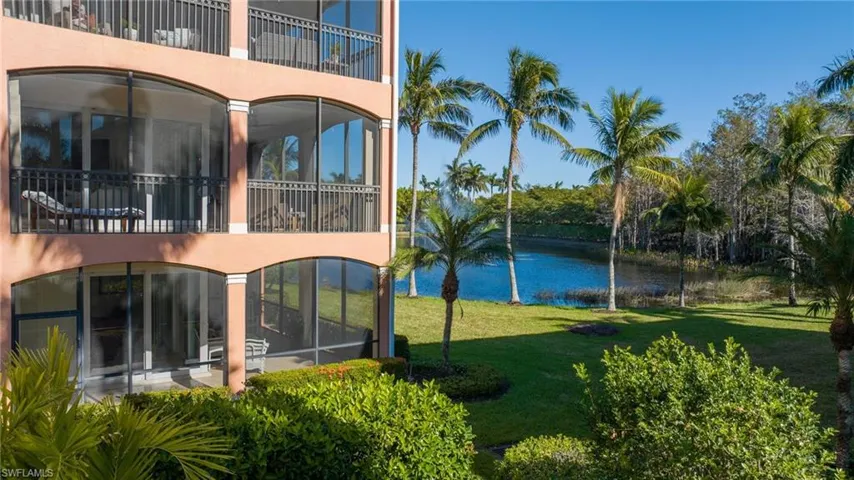 Rear view of house featuring a water view and a lawn