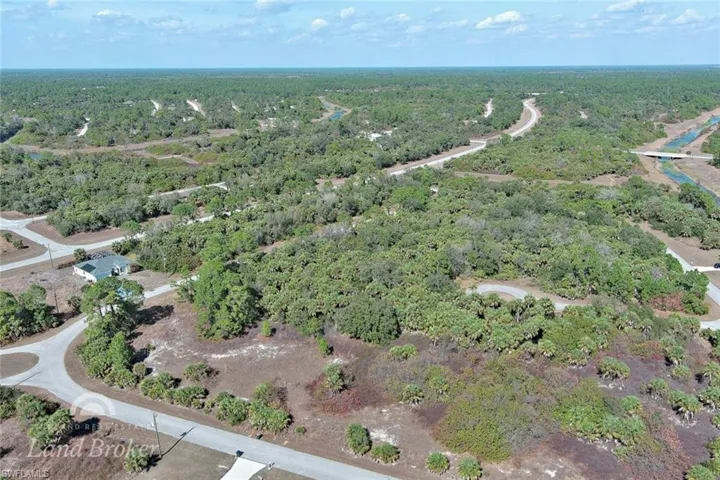 Aerial view of property and surrounding area featuring a forest