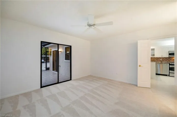 Unfurnished room with a ceiling fan and light carpet