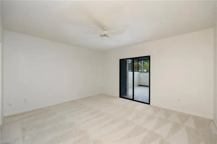 Spare room featuring light colored carpet and ceiling fan