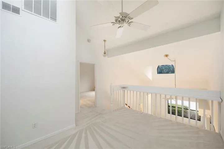 Unfurnished room featuring ceiling fan, carpet, and vaulted ceiling