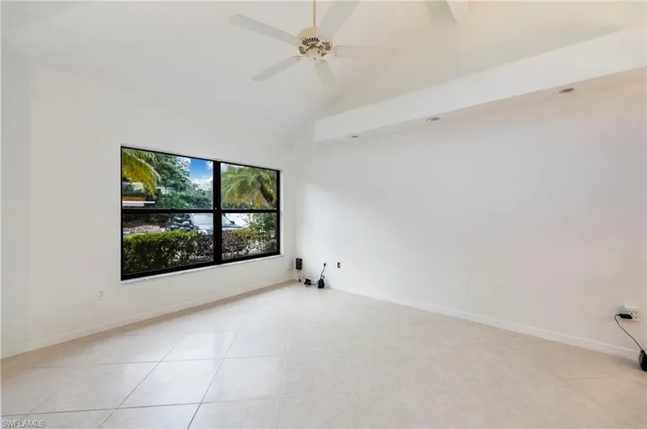 Unfurnished room featuring vaulted ceiling and ceiling fan