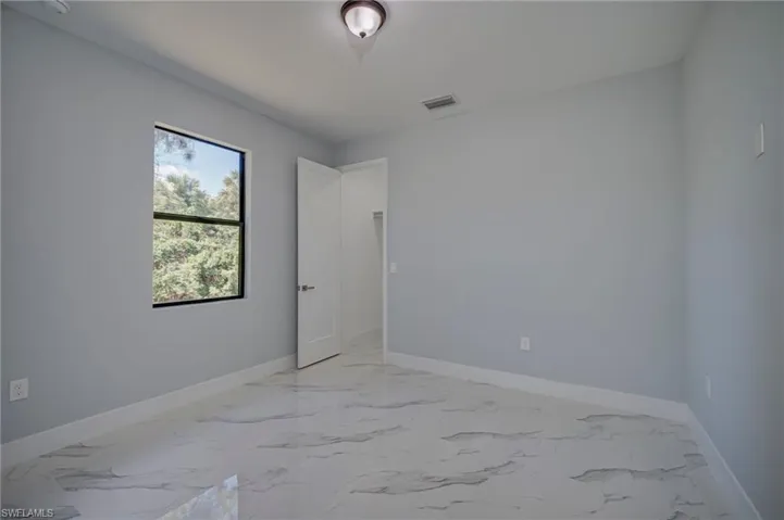 Spare room featuring light marble finish flooring