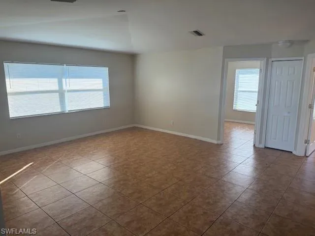 Tiled empty room with healthy amount of natural light