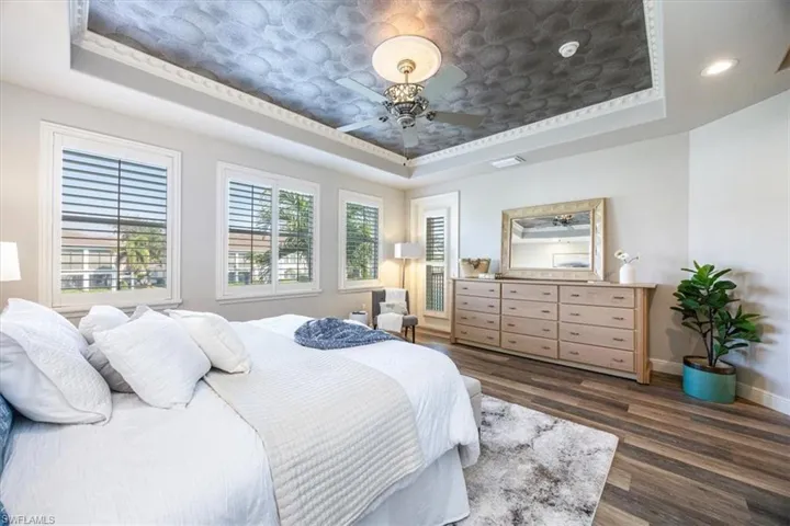 Bedroom featuring dark wood-type flooring and a tray ceiling