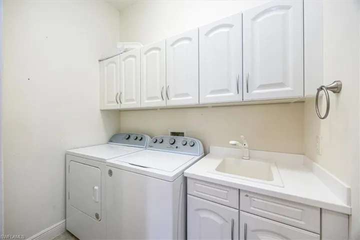 Laundry area with sink, washer and dryer, and cabinets