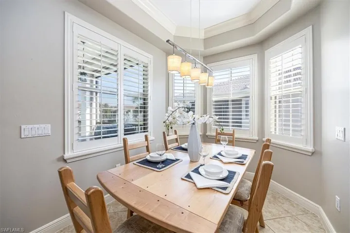 Tiled dining space featuring crown molding