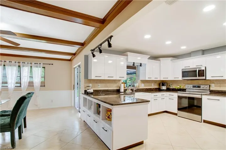 Kitchen with a wealth of natural light, ceiling fan, tasteful backsplash, and range with electric stovetop