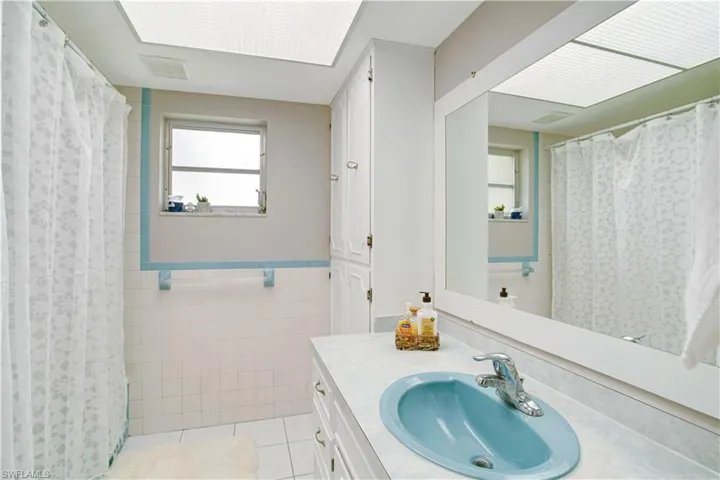 Bathroom with tile floors, tile walls, and large vanity